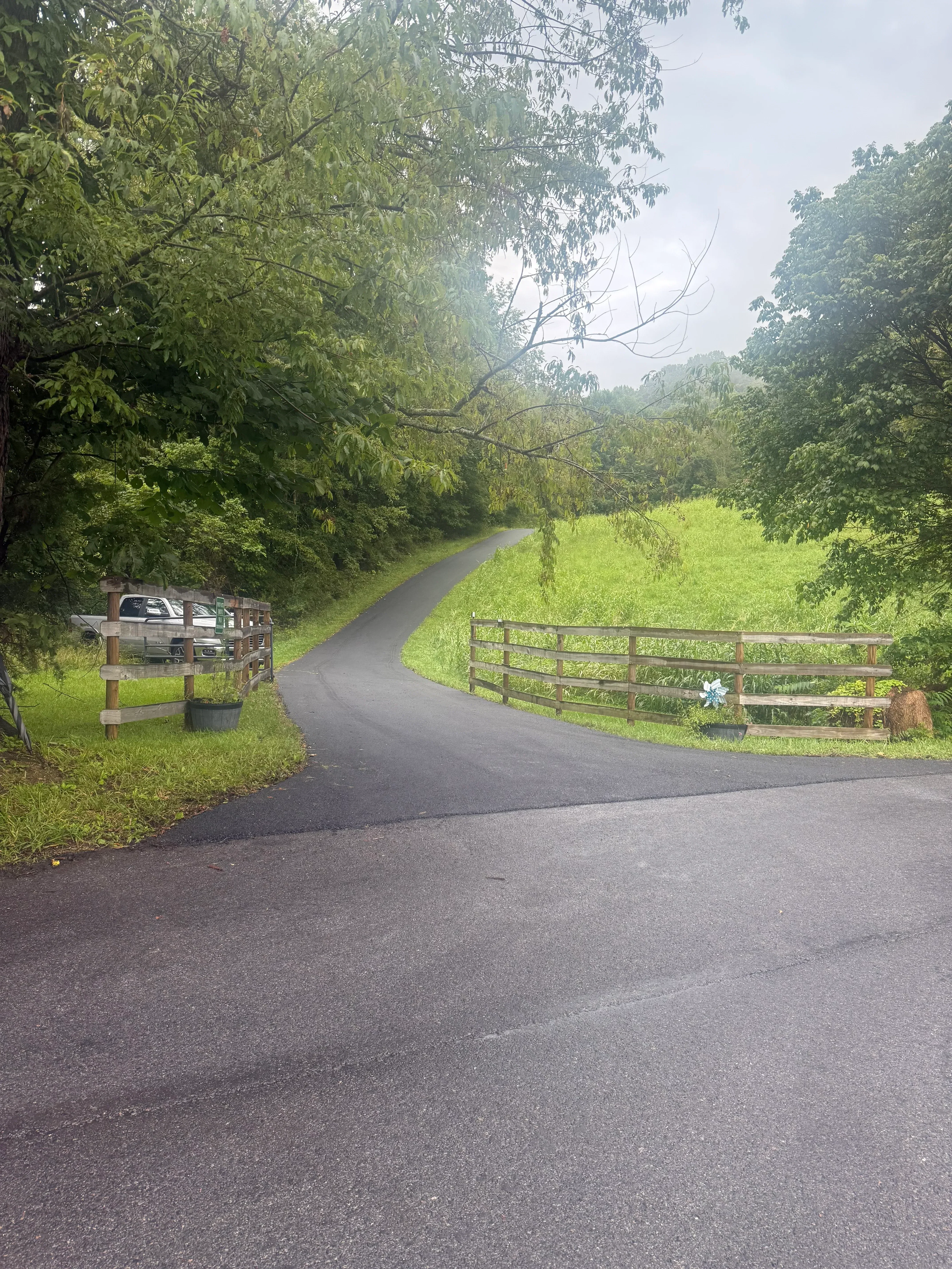 Newly installed asphalt driveway with dark surface and clean edges adjacent to residential property